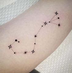 a small star tattoo on the arm with stars and dots in it's center