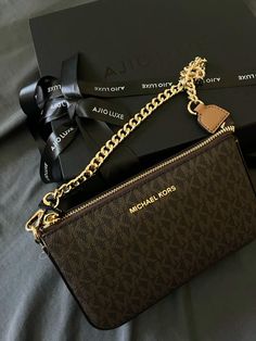 a michael kors bag with a heart charm on it and a black box next to it