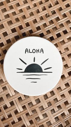 a sticker with the word aloha on it sitting on top of a wicker table