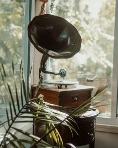 an old fashioned record player sitting in front of a window