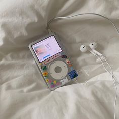 an ipod and headphones laying on a bed