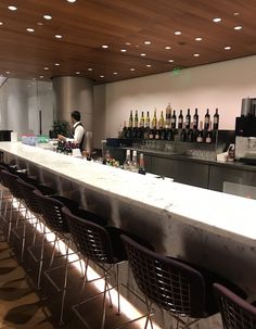 an empty bar with chairs and bottles on the counter