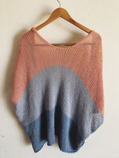 an orange and blue sweater hanging on a hanger