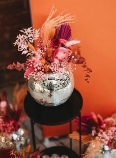 there is a disco ball and some flowers in the vase on top of a table