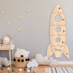 a child's room decorated in neutral tones with stars and a rocket ship wall decal