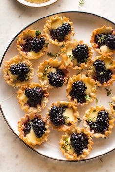 blackberries and cream filled pastries on a white plate