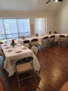 a room filled with tables and chairs covered in white tablecloths