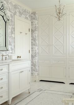 a bathroom with white cabinets and a chandelier