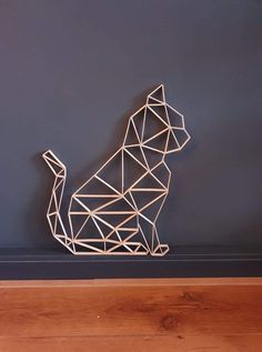 a wooden dog sculpture sitting on top of a hard wood floor next to a blue wall