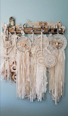 there are many doily hanging on the wall with some laces and other things