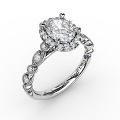 a white gold engagement ring with an oval shaped diamond center surrounded by small round diamonds