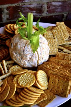 a cheese ball surrounded by crackers on a plate