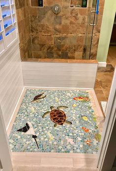 a bathroom with tile flooring and a turtle on the shower mat in front of it