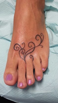 a woman's foot with a tattoo design on the top and bottom part of it