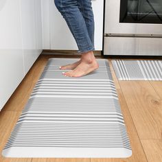 a person standing on a kitchen mat in front of an oven