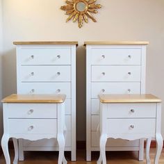 two white dressers with gold trim on the top