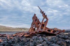 an old rusted metal structure sitting on top of rocks