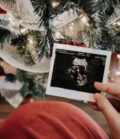 a person holding up an x - ray image in front of a christmas tree