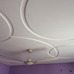 a room with purple walls and ceiling fan