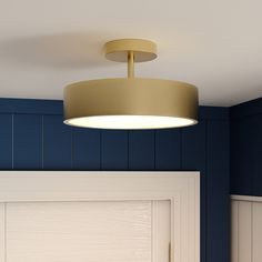 a light that is on above a door in a room with blue walls and wood paneling