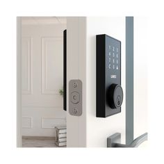 an electronic door lock on the side of a white wall with a plant in it