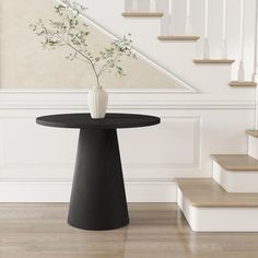 a vase with flowers is sitting on a table in front of some stairs and banisters