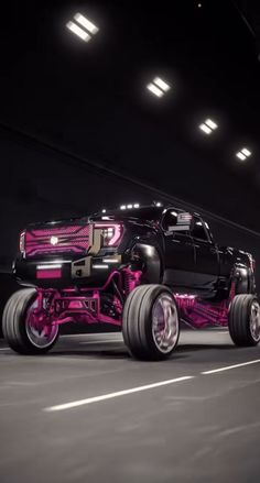 a pink and black truck driving down a street