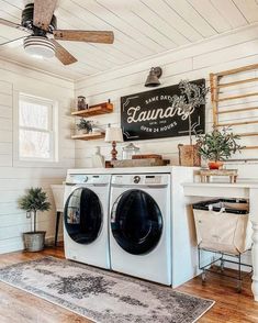 a washer and dryer in a room with white walls, wood floors and ceiling fan