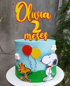 a birthday cake with a snoopy dog and balloon on top that says olliwa mees