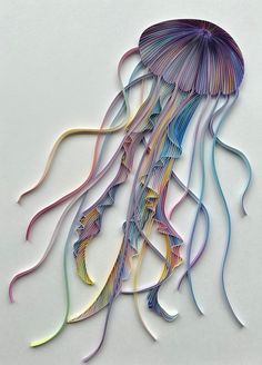 a multicolored jellyfish is hanging on the wall in front of a white background