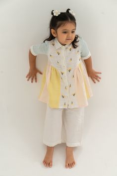 Editor's Note There's nothing like a little kid and some cotton candy. Featuring hand embroidered tulips paired with multicolour khadi panels and peach white trousers. This coming season go ethnic with your kid styling this outfit cute hairclips and a pair of jutti's Fabric: Handloom Khadi Color: Pearl White, Skyblue, Yellow and pink Care: Dry Clean Only About the Designer The right cut believes in travel & textiles, authentic & progressive, new age dynamism. Cute Hairclips, Embroidered Tulips, Kids Frocks Design Cotton, Stylish Boy Clothes