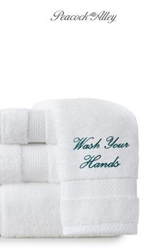 two white towels with the words wash your hands written on one side and green lettering on the other