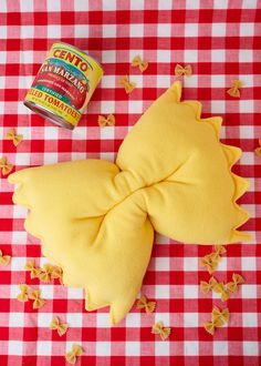 a can of tuna paste next to a stuffed animal on a checkered tablecloth