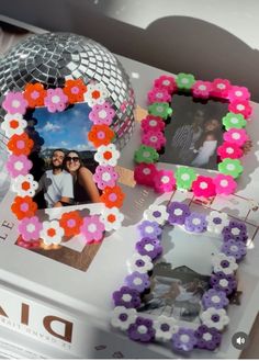 a table topped with pictures and flowers on it's side next to a disco ball