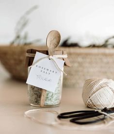 a wooden spoon sitting on top of a table next to a jar filled with yarn