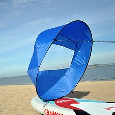 a blue and white sail sitting on top of a surfboard