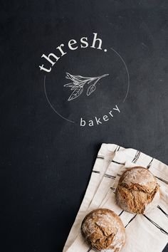 two pastries sitting on top of a white napkin next to a blackboard with the words fresh bakery