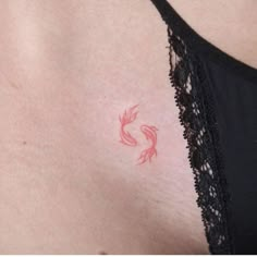 a woman's chest with a red tattoo on the left side of her stomach