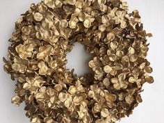 a wreath made out of gold leaves on a white background