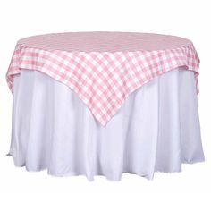 a pink and white checkered table cloth on top of a round table with a ruffled edge