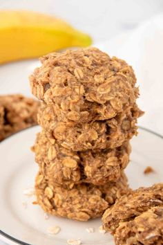 three oatmeal cookies stacked on top of each other in front of a banana