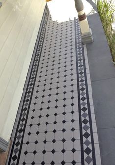 a black and white tiled walkway next to a building