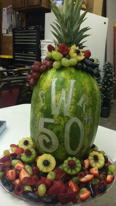 a watermelon decorated with fruit and the number 50 on it's side