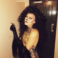 a woman with long black hair and makeup is dressed up as a cat for halloween