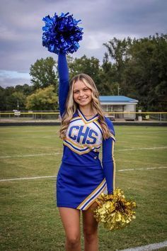 a cheerleader is holding her pom - poms in the air while standing on a football field