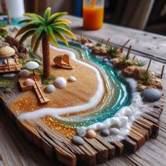 a beach scene made out of wood with shells, sand and palm trees on it