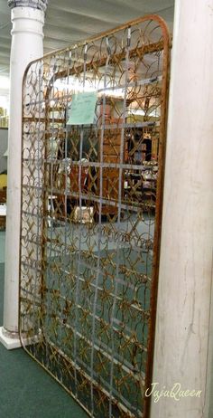 an old iron gate is in the middle of a room with green carpet and white pillars