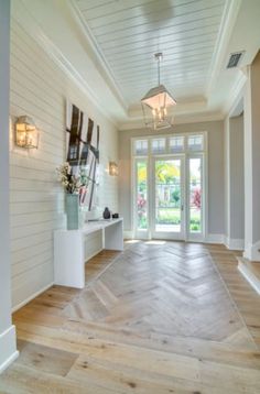 an empty room with wood floors and white walls