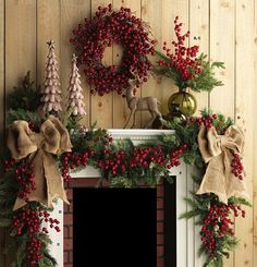 a fireplace decorated for christmas with wreaths and decorations