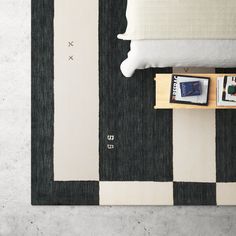 a black and white striped rug on the floor next to a bed with two nightstands